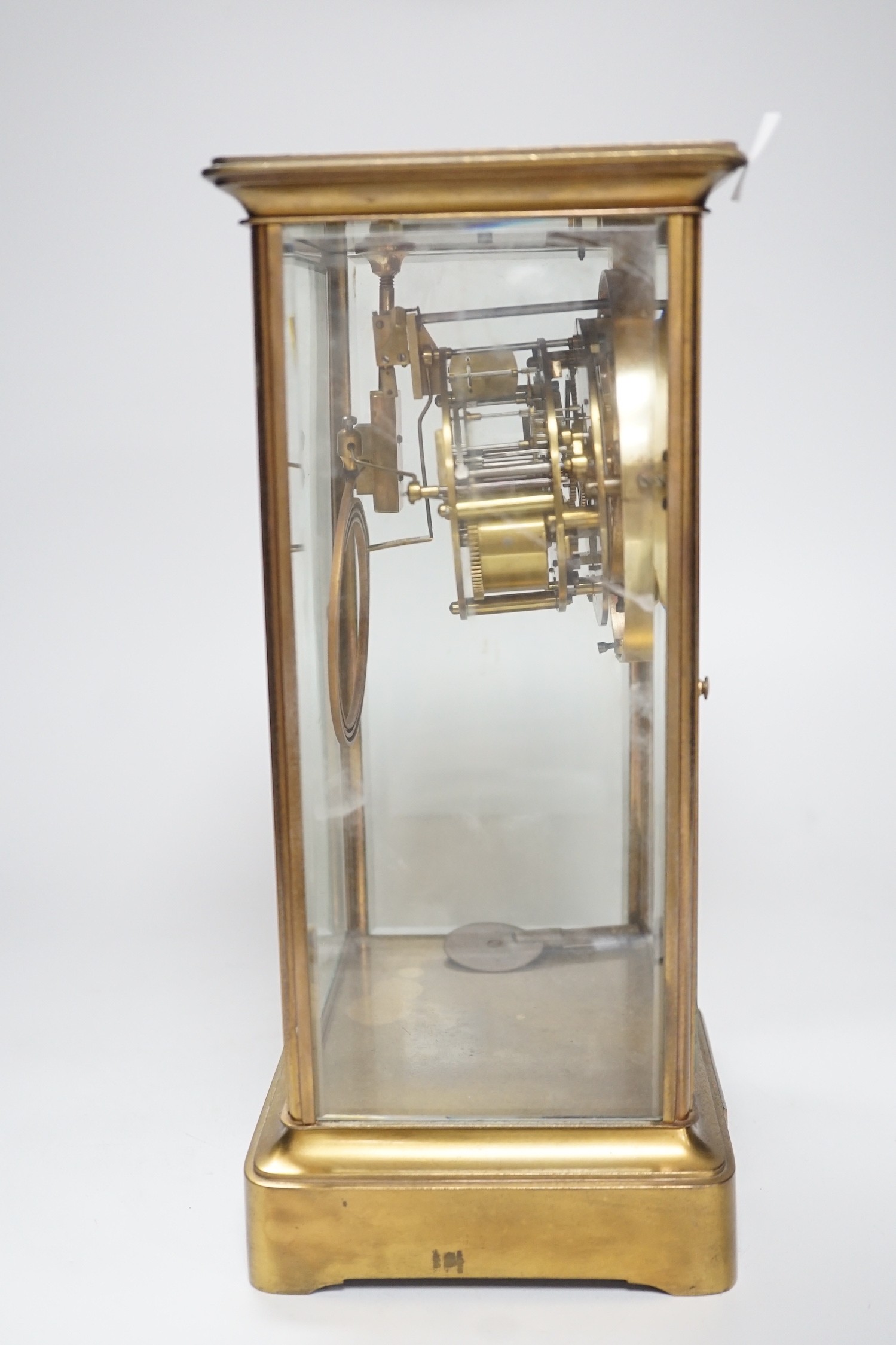 An Edwardian brass four-glass mantel clock with pendulum, presentation plaque to base, 30cm tall